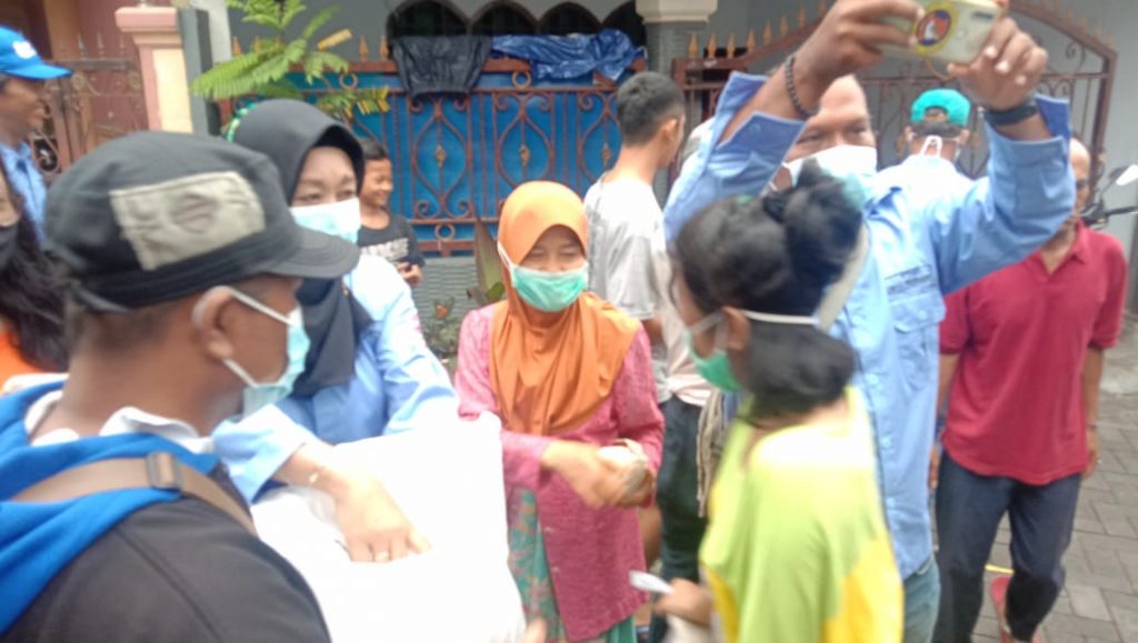 Pembagian bungkus Pengurus KOMPS ( Komunitas Masyarakat Peduli Surabaya ) kepada masyarakat Banyu Urip