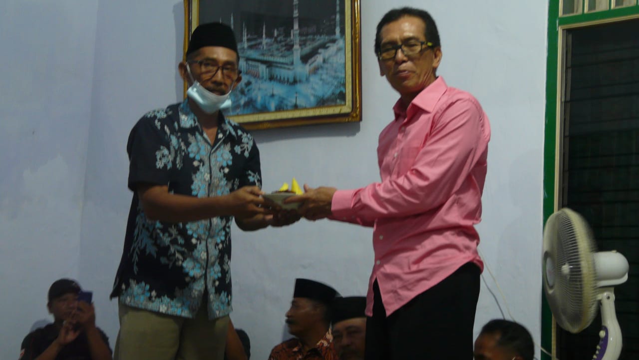 Kepala Desa Pilang H. Alfadi, SH menerima Potong tumpeng dari Tokoh Masyarakat Warga Pilang